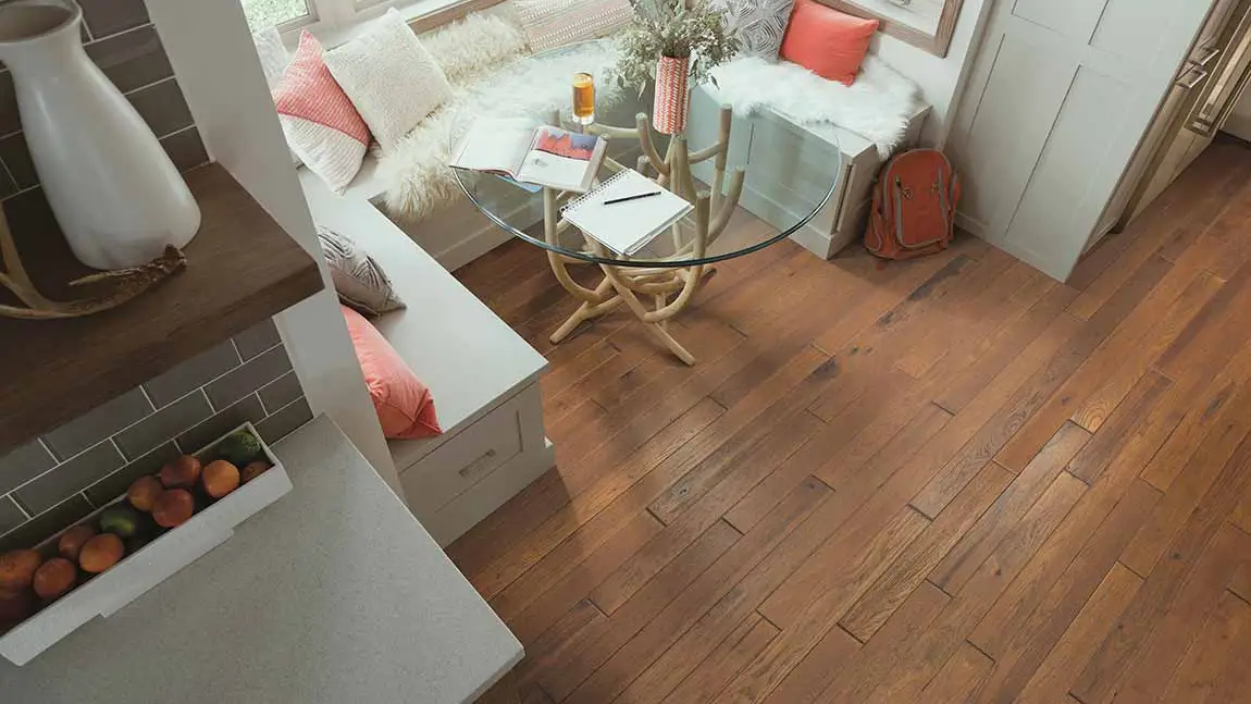 dark stained hardwood floors in a kitchen breakfast nook with glass table and coral accents